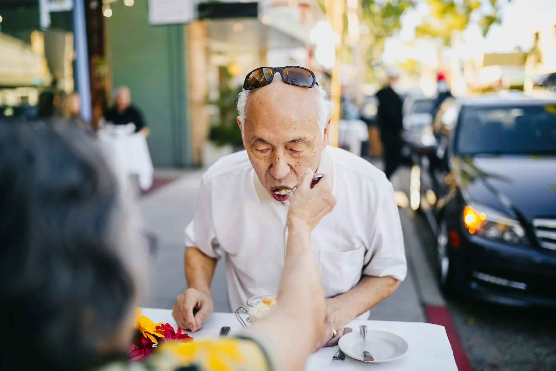 man in white polo shirt wearing black sunglasses on his head
