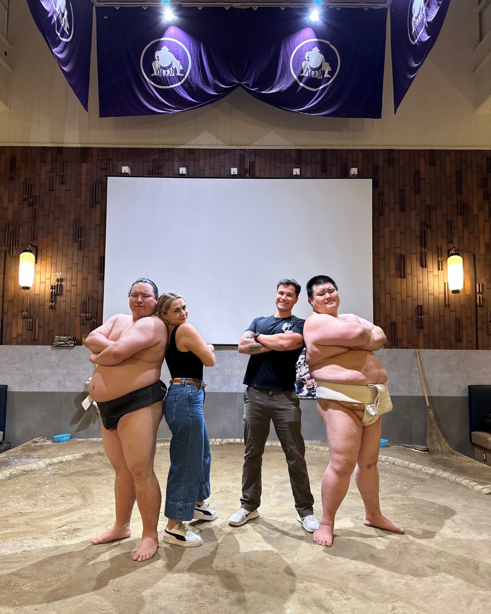 Kallie and Carlos with two sumo wrestlers in a sumo ring in Japan - NCPI travel CEU trip 2027